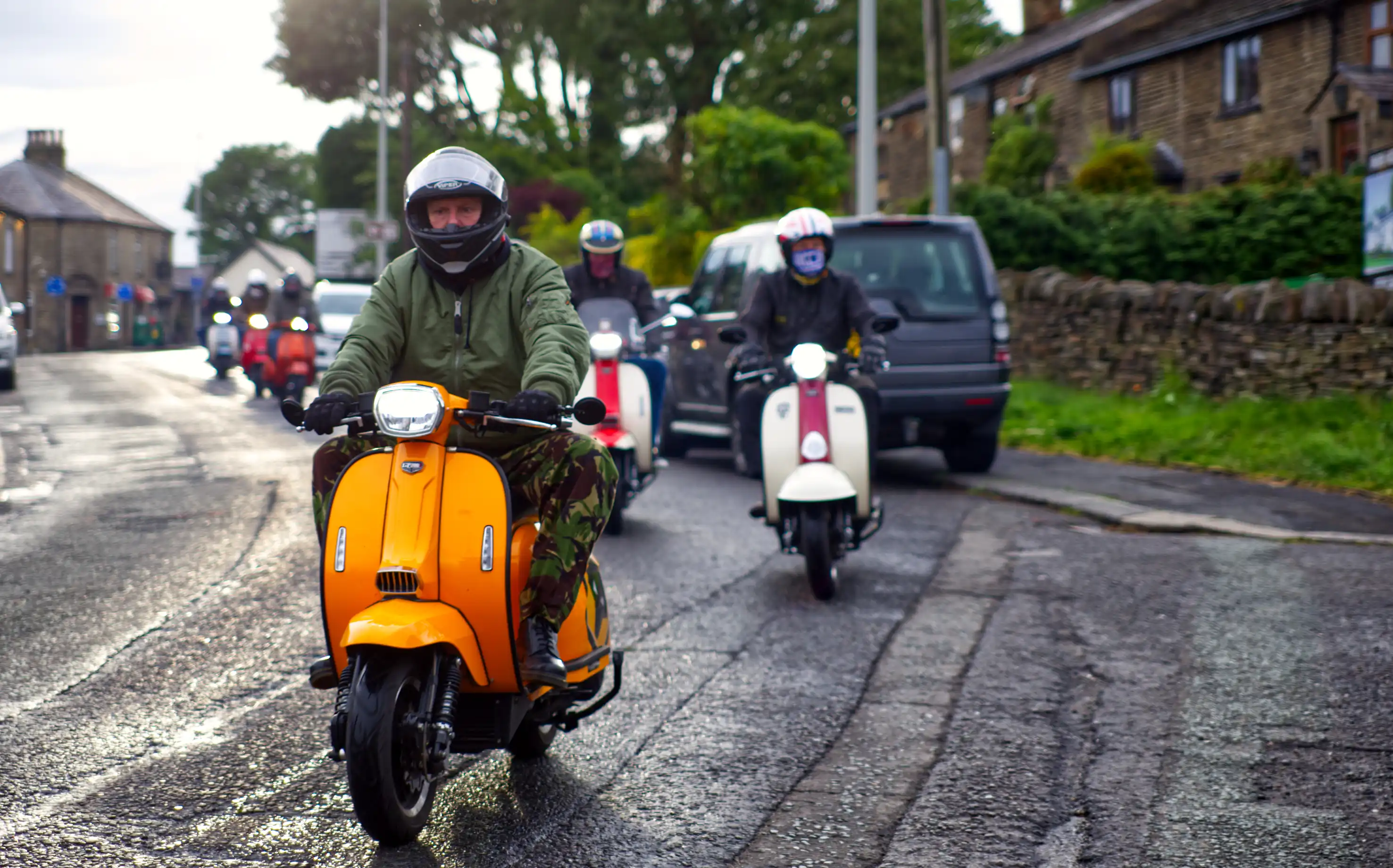 Een groep scooterrijders met helm en jas op Royal Alloy en Lambretta